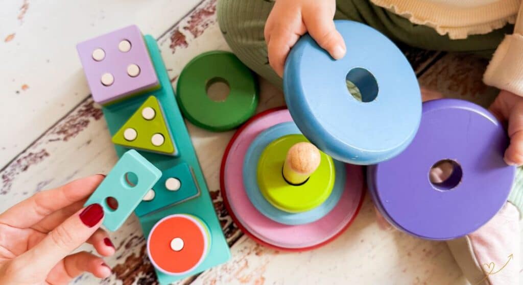 Brinquedos coloridos em forma circular sendo usado por um bebê.