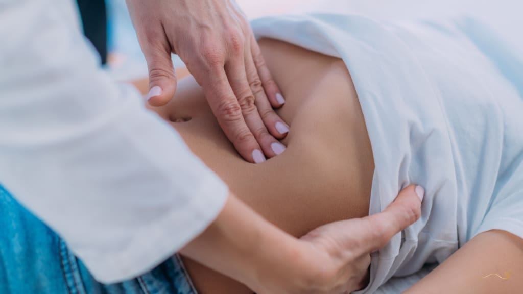 profissional avaliando abdómen de uma mulher.
